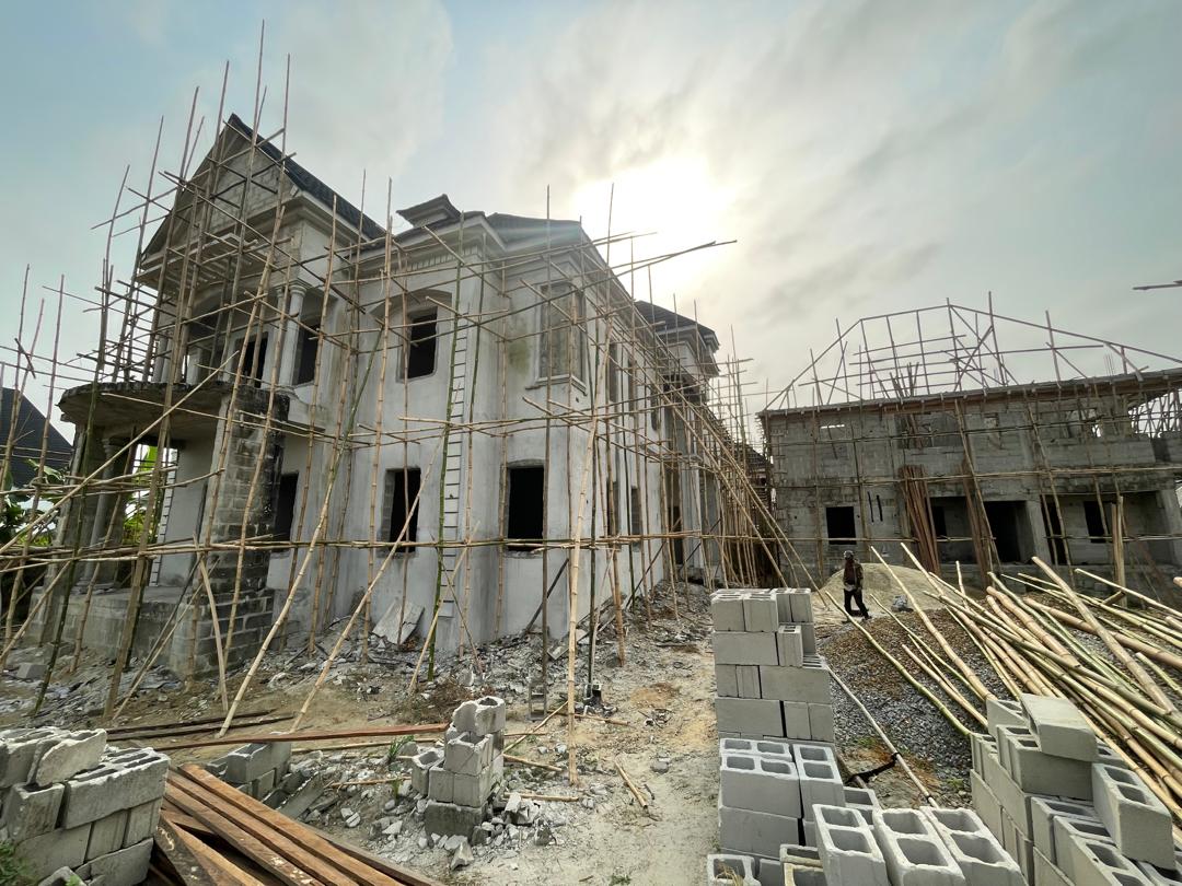 Partially enclosed multi-storey building shell with scaffolding.